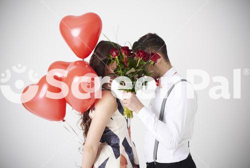 Bouquet Of Red Roses Covering Couple Kiss